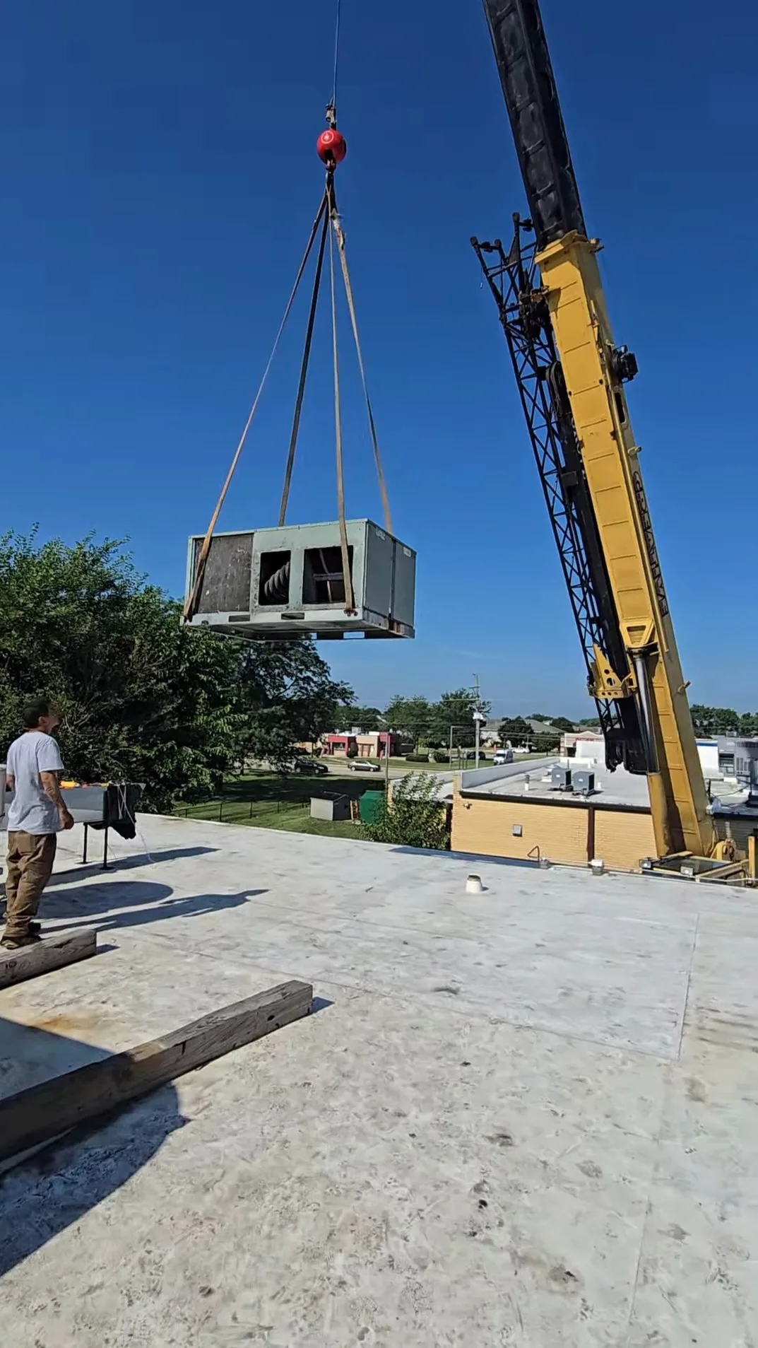 Crane lifting a commercial rooftop HVAC unit — Heavy Duty Heating and Cooling installation